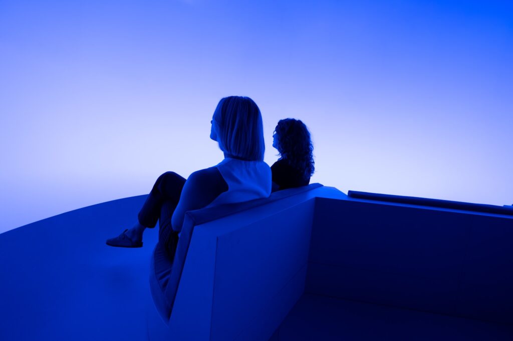 Two visitors in blue light inside Chasing the Dot
