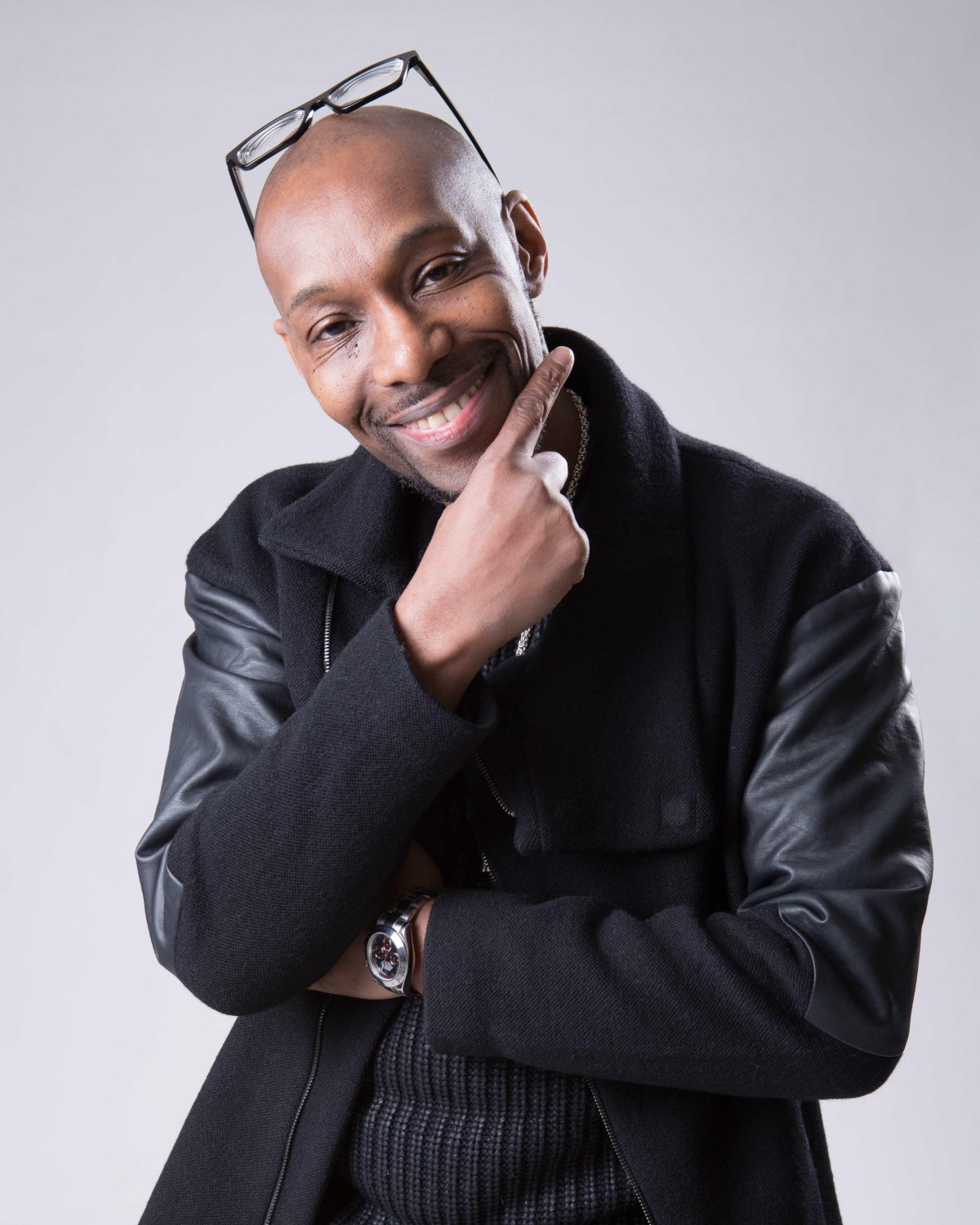 Mr Cee, host of Come Mek We Larf, smiling with his hand on his chin
