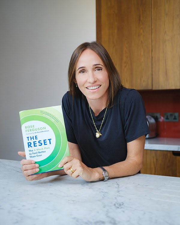 Rose Ferguson holding a copy of her book The Reset