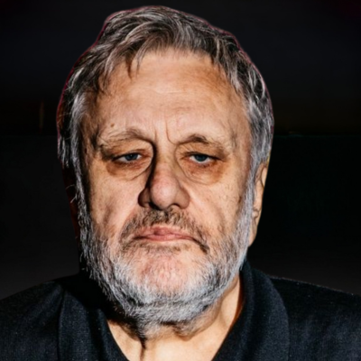Portrait of Slavoj Žižek against a dark background