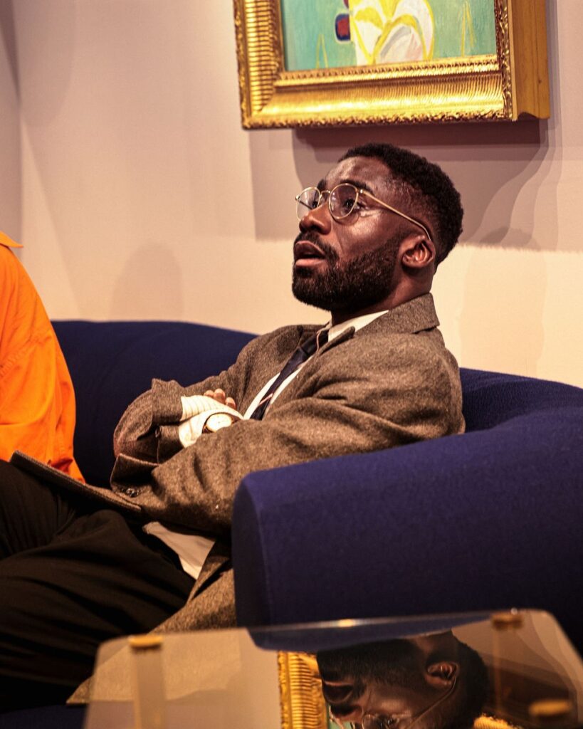 A guest listens from a sofa in the Salon